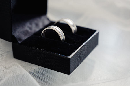 The bride and groom's wedding rings are in a black heart-shaped case.