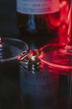 Gold wedding rings lie on a glass tableの写真素材