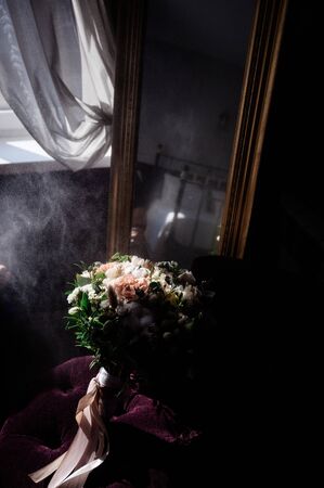 Wedding rings of the bride and groom are on the flowers closeupの写真素材