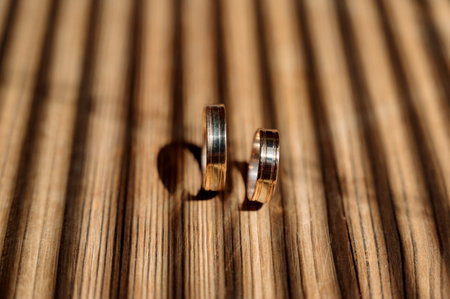 Wedding rings on a beautiful wooden texture surface closeup
