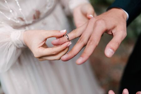 The bridegroom puts the wedding ring on the bride close up.の写真素材