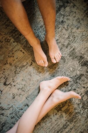 Feet of man and woman in bed in the morning close-upの写真素材