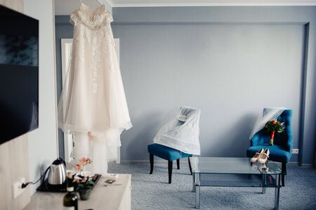 White wedding dress hanging in the bedroom. White bride dress close upの写真素材