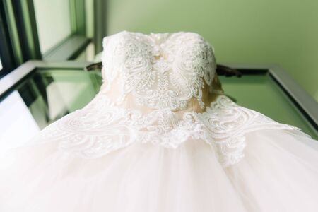 White wedding dress hanging in the bedroom. White bride dress close upの写真素材