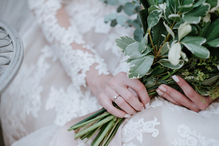 Bride in a wedding dress holding a wedding bouquet in her hands