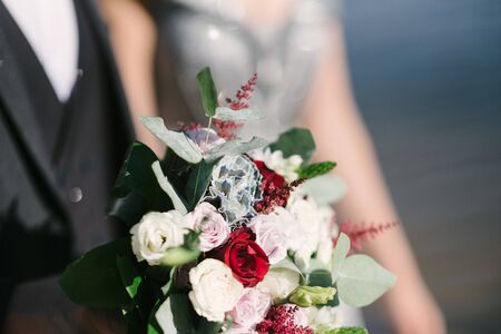 Bride in a wedding dress holding a wedding bouquet in her handsの写真素材