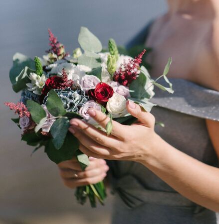 Bride in a wedding dress holding a wedding bouquet in her handsの写真素材