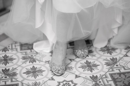Shoes on the feet of the bride in a wedding dressの写真素材