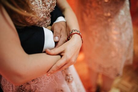The groom in a suit hugs the bride in a wedding dress close upの写真素材