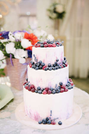 Big white wedding cake with fruit is on the table close upの写真素材