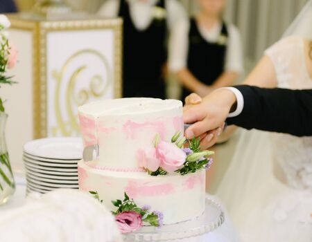 Bride and groom cut the wedding cakeの写真素材