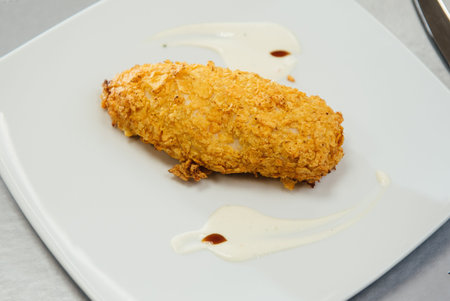 Chicken breast breaded on a plate on the tableの写真素材