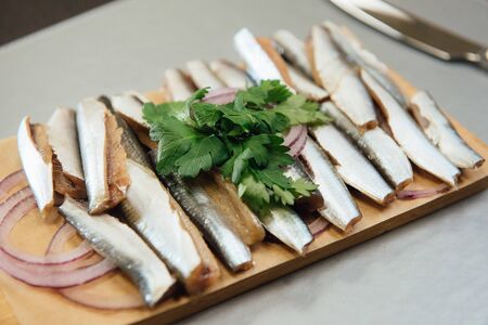 fresh sprat with greens on a cutting board on the tableの写真素材