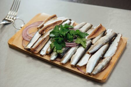 fresh sprat with greens on a cutting board on the tableの写真素材