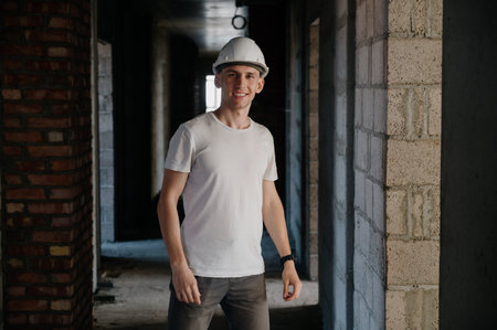 Portrait of a worker in a construction site.View of an attractive worker in helmet at construction...