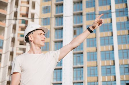Portrait of a worker in a construction site.View of an attractive worker in helmet at construction siteの写真素材