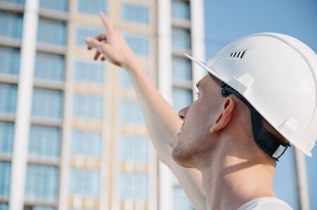 Portrait of a worker in a construction site.View of an attractive worker in helmet at construction siteの写真素材