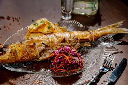 Fish dish - fried fish fillet with vegetables on a dark wooden background.Top view