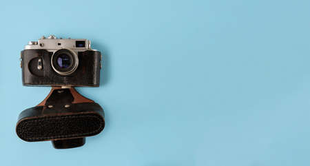 Retro photo camera on blue background, flat layの写真素材