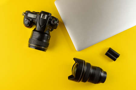 Photographer's equipment.Flat lay composition with photographer's equipment and laptop on yellow background. Photographer's workplace on a yellow background.Copy spaceの写真素材