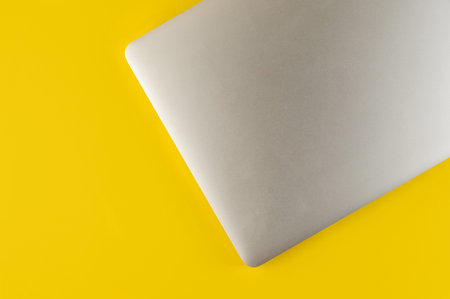 Top view of laptop and mouse on yellow background.Flat lay composition with notebook and mouse on...