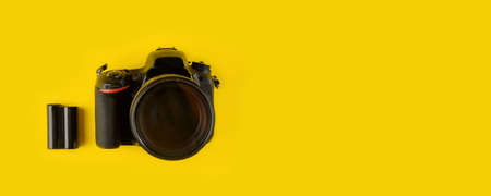 Photographer's equipment. Flat lay composition with photographer's equipment and accessories on yellow background.Camera and batteries on a yellow background, top view.の写真素材
