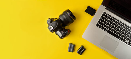 Photographer's equipment.Flat lay composition with photographer's equipment and laptop on yellow...