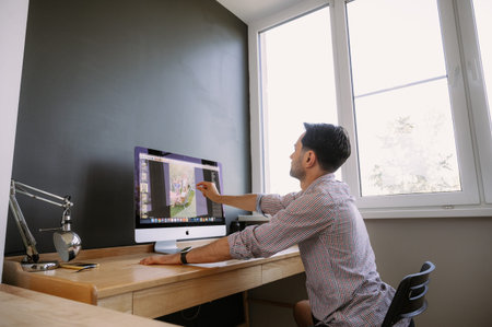 Professional Photographer Works in Photo Editing App. Software on His Personal Computer.Photographer...