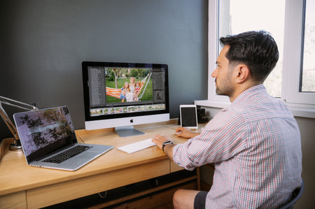 Professional Photographer Works in Photo Editing App. Software on His Personal Computer.Photographer...
