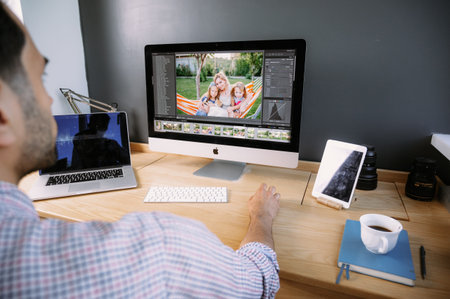 Professional Photographer Works in Photo Editing App. Software on His Personal Computer.Photographer...