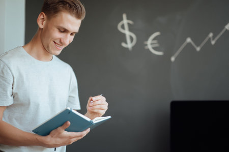 Smiling young man holding a folder with documents in his hands on the background of drawn business...