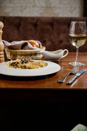 Creamy mushroom spinach pasta. Spaghetti pasta with mushrooms, creamy sauce and parsley on wooden...
