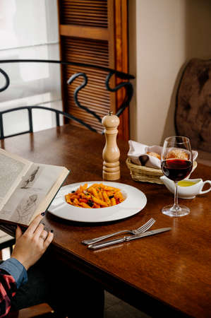 Spaghetti pasta with tomatoes and parsley on wooden table. Pasta penne with tomato sauce, fresh basil and roasted tomatoesの写真素材