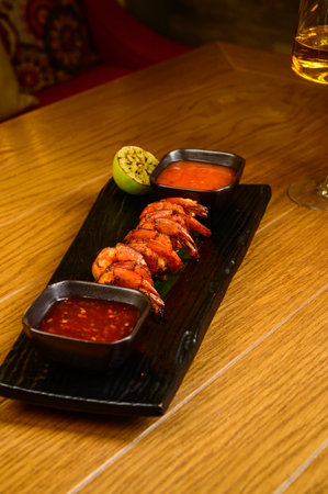 Delicious roasted shrimps on skewers with sauce and lemon. Top view with copy space. Flat layの写真素材