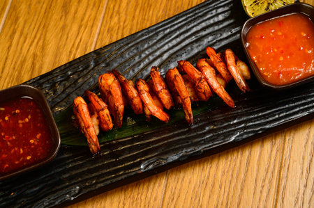 Delicious roasted shrimps on skewers with sauce and lemon. Top view with copy space. Flat layの写真素材
