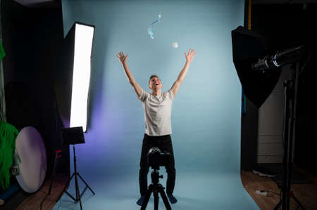Young man tearing medical mask in studio. Removing mask, quarantine ends. Getting out of isolationの写真素材