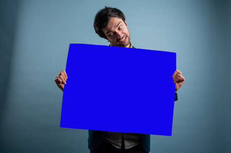 Surprised man with empty advertising banner. Man holds board for advertising. Handsome man with sign board. Space for text. Advertising. Black friday.の写真素材