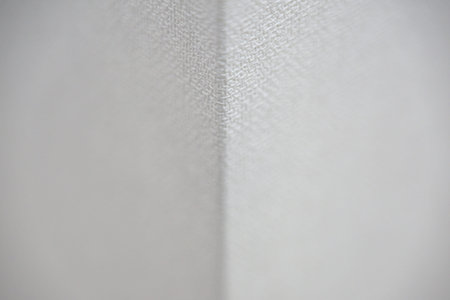 Detailed close-up view of a white fabric corner, showing its texture and weave under soft lighting, emphasizing the material's quality and appearanceの写真素材