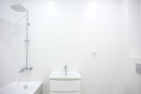 Contemporary bathroom features a showerhead, bathtub, and sink with sleek cabinetry, all set against...