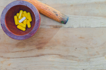 medicine capsules in wooden bottle, on wooden table, copy spaceの写真素材