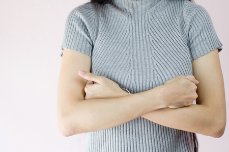 Woman hand checking lumps on her breast for signs of brest cancer on crepe pink background, healthy lifestyle conceptの写真素材