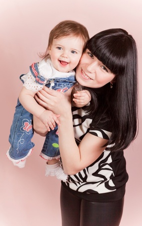 Happy joyful mother with laughing little daughte in studioの写真素材