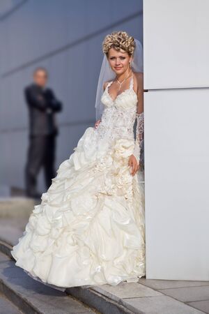 Caucasian mid-adult bride and groom standing on porch looking at viewer and smiling.の写真素材