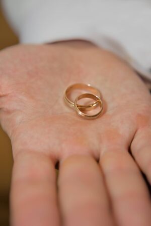 Pair of gold wedding rings on a palmの写真素材