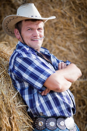The cowboy with a cigaret. The young beautiful guy in a cowboyの写真素材