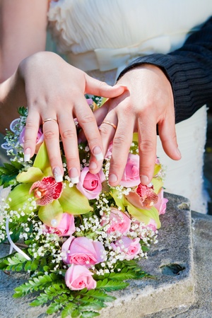 Hands and rings on wedding bouquetの写真素材