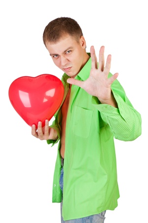 Young guy holding a red heart-shaped balloon on a white backgroundの写真素材