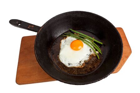 Fried eggs on a frying pan on a board on the isolated white backgroundの写真素材