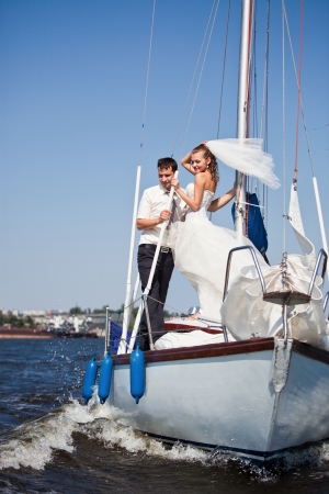Happy groom and the bride on the yacht in solar and bright dayの写真素材