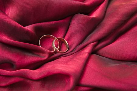 Two gold wedding rings on the redの写真素材